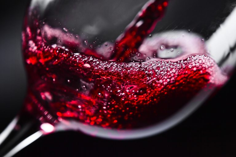 Red,Wine,In,Wineglass,On,Black,Background
