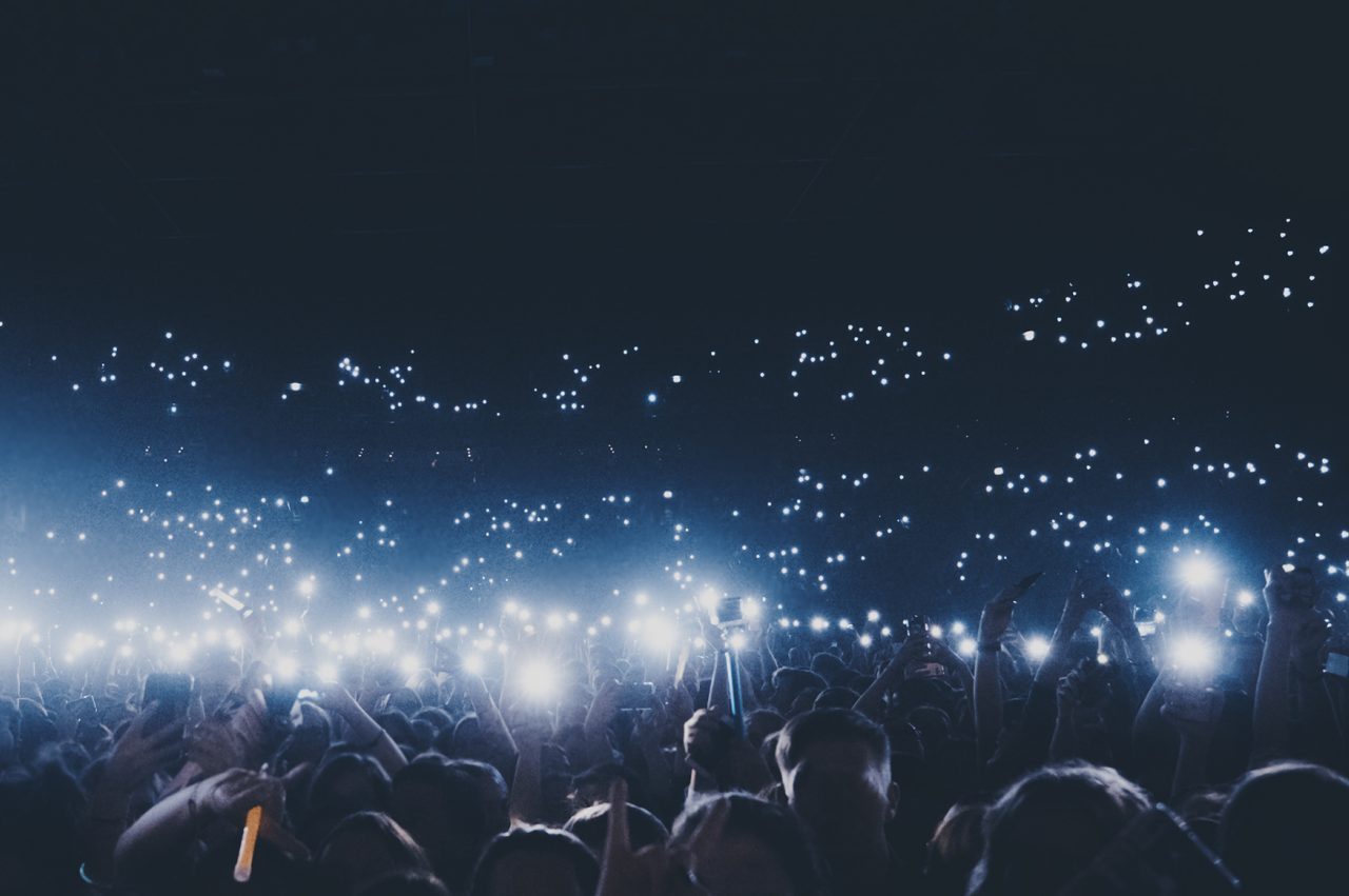 Group of people holding cigarette lighters and mobile phones at a concert